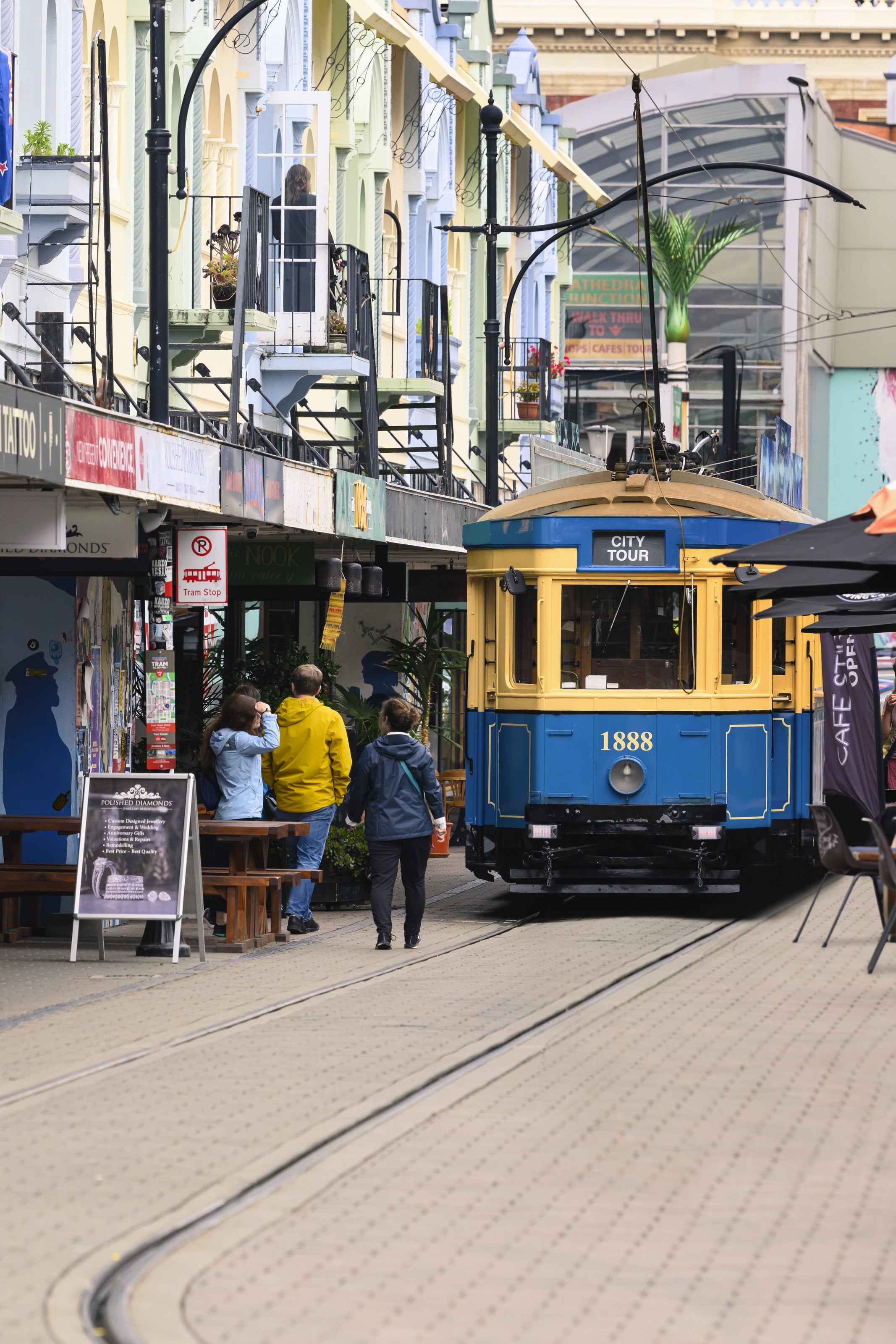 A heritage tram on New Regent Street, Christchurch, pastel Spanish Mission facades behind it